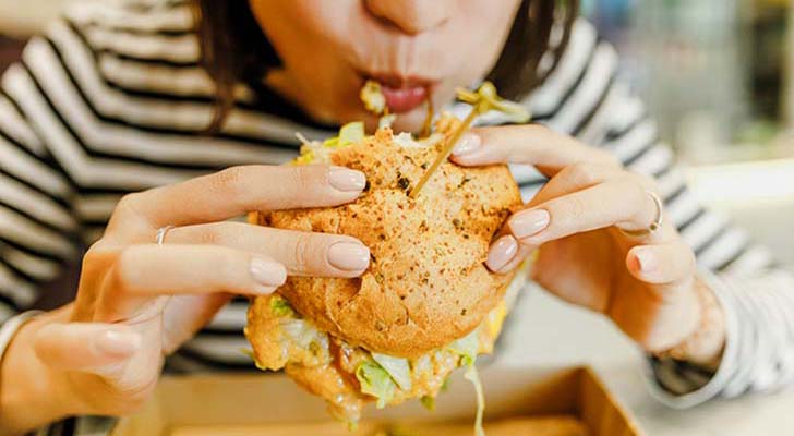 Mulher a comer fast-food